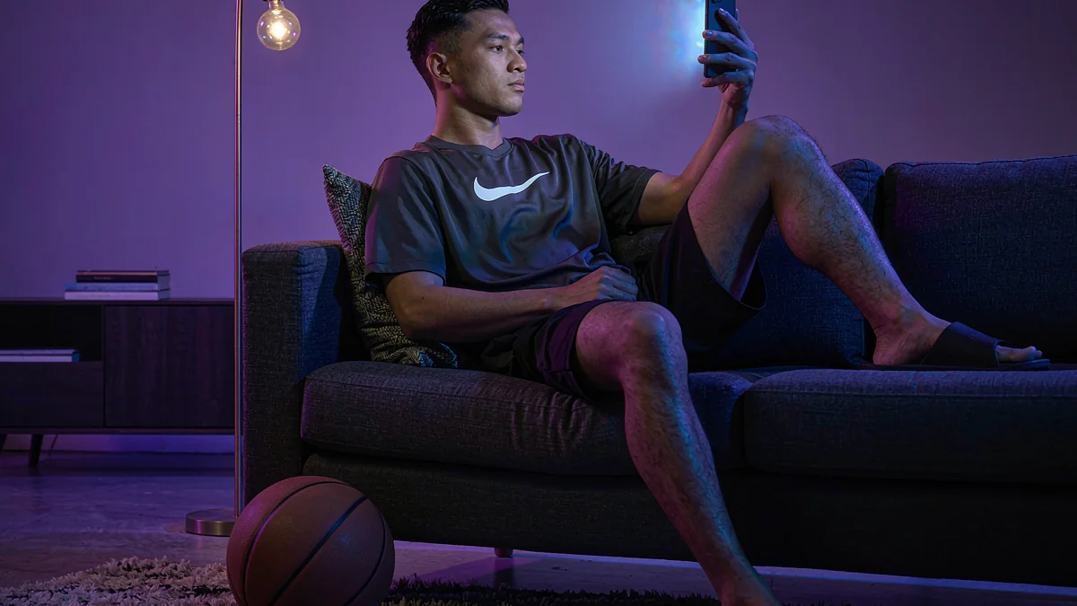 Jolibet adult using a phone beside a basketball